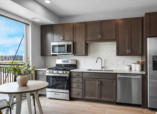 a kitchen with dark wood cabinets and stainless steel appliances