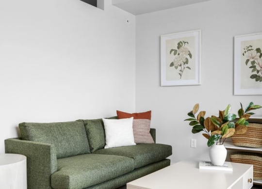 a living room with a green couch and a white coffee table