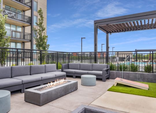a patio with couches and a fire pit at the district flats apartments in lenexa