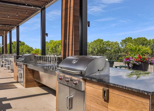 an outdoor kitchen with stainless steel appliances and a bar
