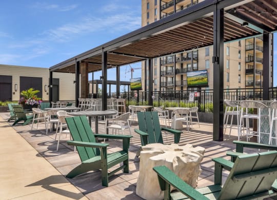 a patio with chairs and tables and a building in the background