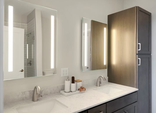 a bathroom with two sinks and two mirrors