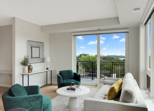 a living room with a white couch and two green chairs