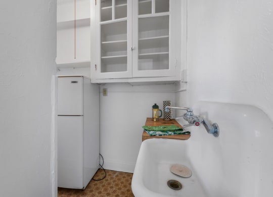 a small kitchen with a sink and a refrigerator