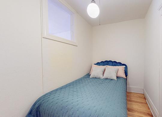 A small bedroom with a bed and a window.