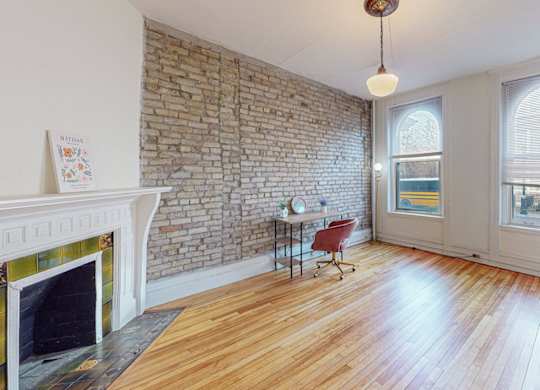 A room with a fireplace and a brick wall.
