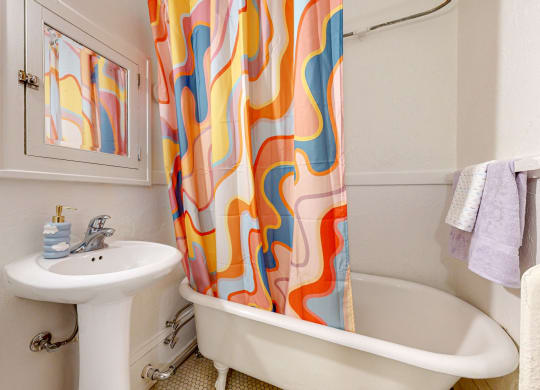 a bathroom with a bathtub sink and mirror