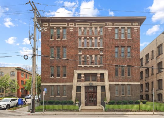 a red brick building with a large doorway and a black wrought iron fence in front of it