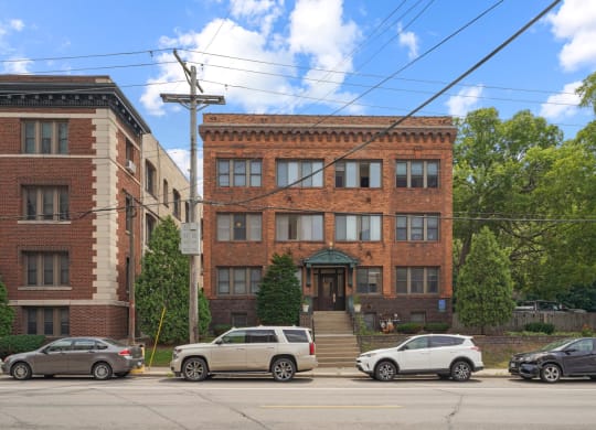 a brick building on a street corner with cars parked in front of it