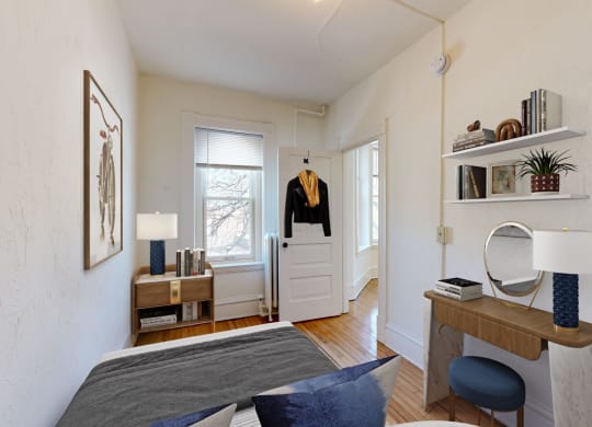a small bedroom with a bed and a desk