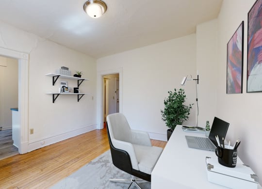 a home office with white walls and hardwood floors