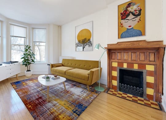 a living room with a yellow couch and a fireplace