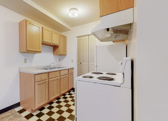 a kitchen with white appliances and a checkered floor