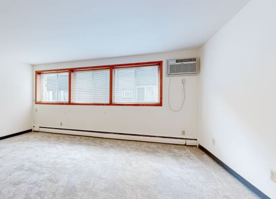 a bedroom with white walls and a large window