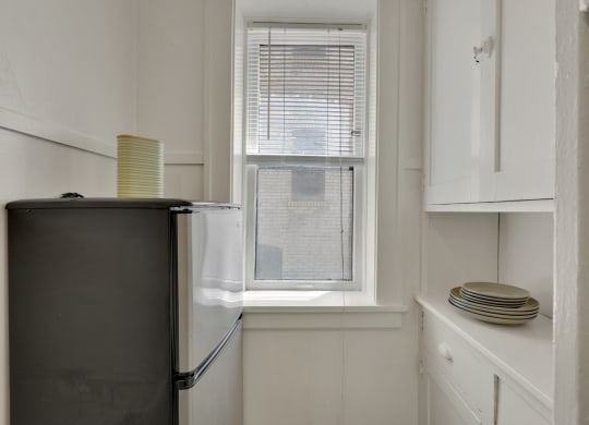 a small kitchen with a refrigerator and a window