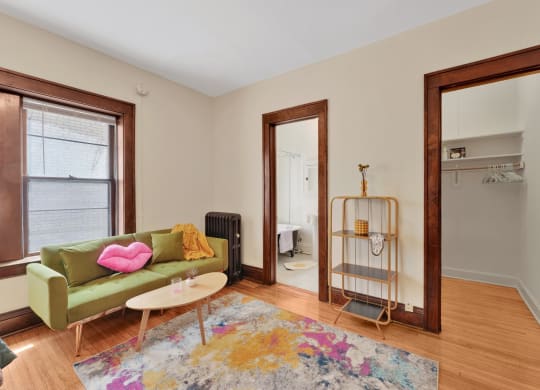 a living room with a green couch and a rug