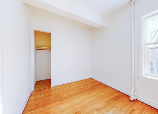 Cozy Bedroom with Restored Hardwood Floors and a Large Windows at The Park Apartments in Minneapolis, 55403