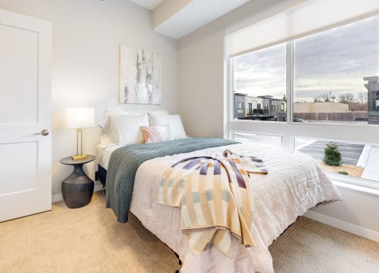 a bedroom with a bed and a large window