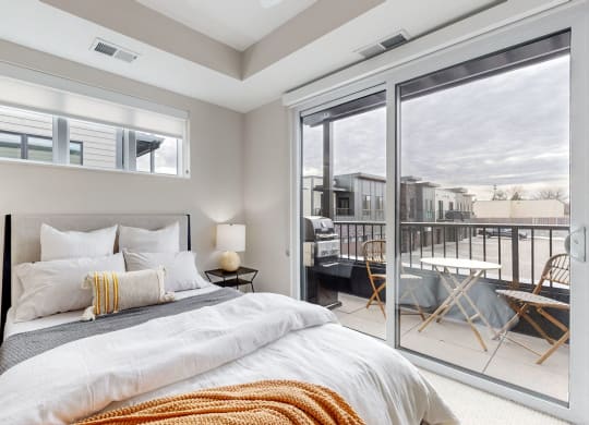 a bedroom with a bed and a sliding glass door to a balcony