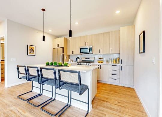 a kitchen with a island and three chairs