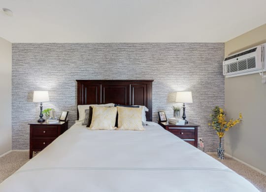 a bedroom with a large bed and two nightstands with lamps on them