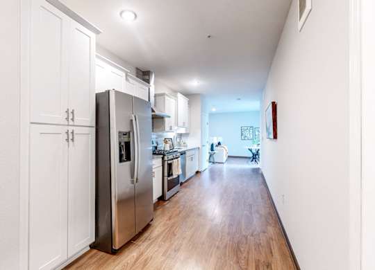 A kitchen with white cabinets and a refrigerator.