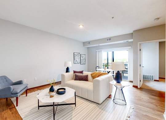 A living room with a white couch and a grey chair.
