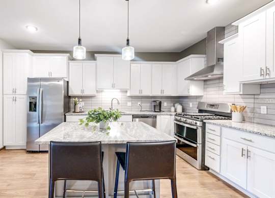 A kitchen with a table and chairs in the middle of it.