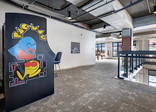 a mural of a cartoon character on a video game machiene in a room with a staircase in the