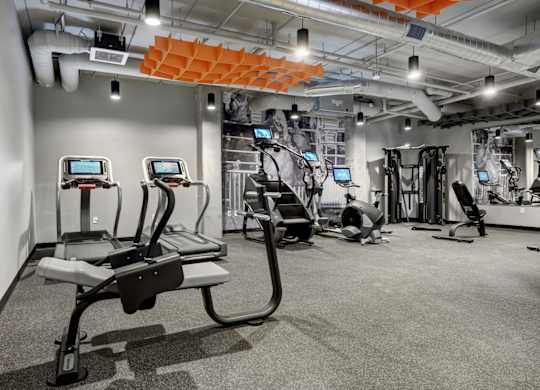 a spacious workout room with treadmills and other exercise equipment