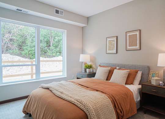 Bedroom with cozy bed and lamps at The Yards, South St. Paul, MN, 55075