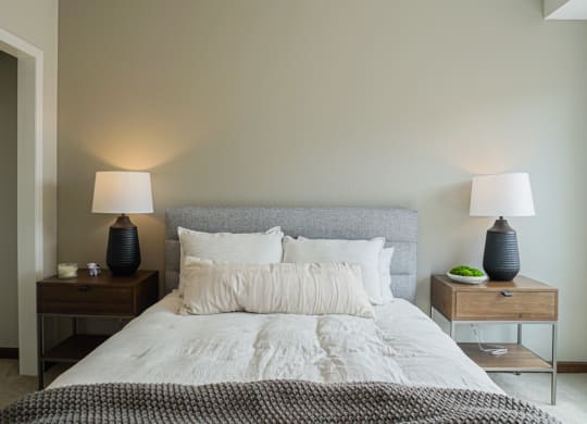 a bedroom with a bed and two nightstands with lamps on them at The Yards and Backyards, MN 55075