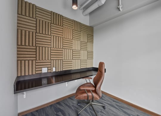 a chair sits in front of a long desk in an office