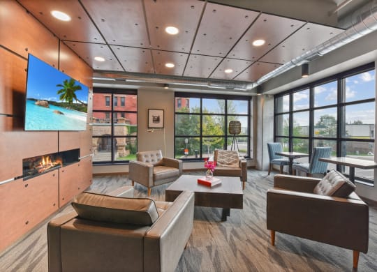 a lounge area with couches chairs and a coffee table with a vase of flowers on