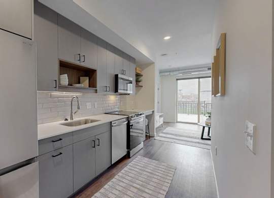 A modern kitchen with stainless steel appliances and white cabinetry.at Tyler Street Stacks, Minneapolis, MN