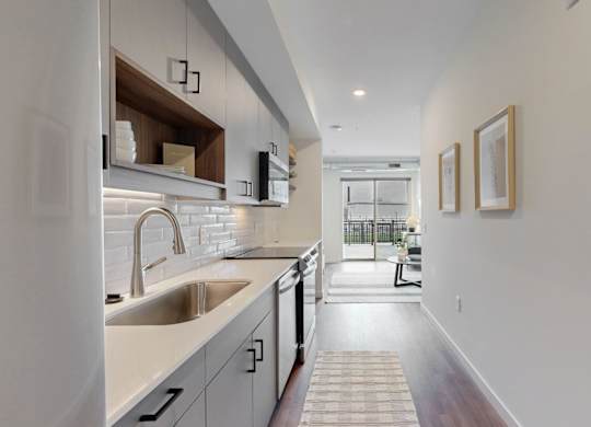 A modern kitchen with a white countertop and stainless steel appliances.at Tyler Street Stacks, Minneapolis