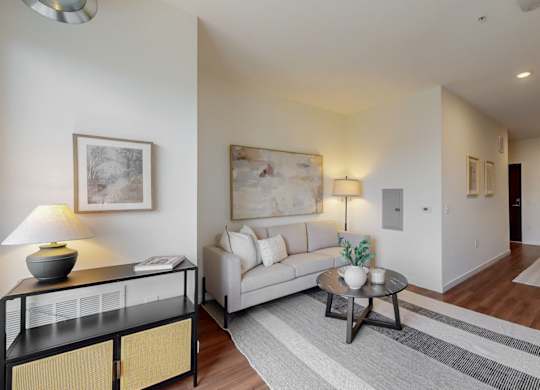 A living room with a white couch, a coffee table, and a lamp.at Tyler Street Stacks, Minneapolis