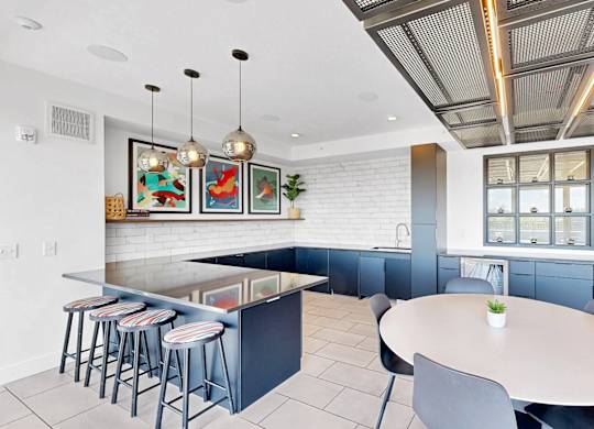 A modern kitchen with a bar area and a dining table.