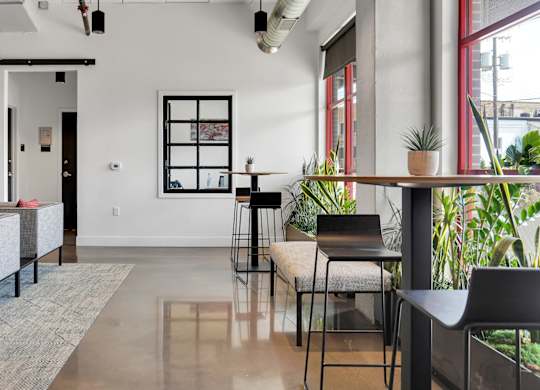 A modern living room with a grey sofa and a glass table.