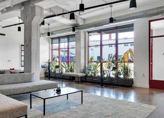 A living room with a couch, a coffee table, and a large window.