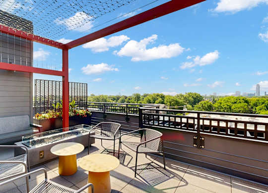 A red and white balcony with a table and chairs.