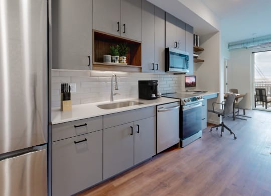 a kitchen with white cabinets and a stainless steel refrigerator at Tyler Street Stacks, Minneapolis