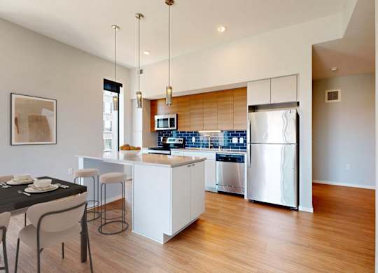A modern kitchen with a dining table and chairs.