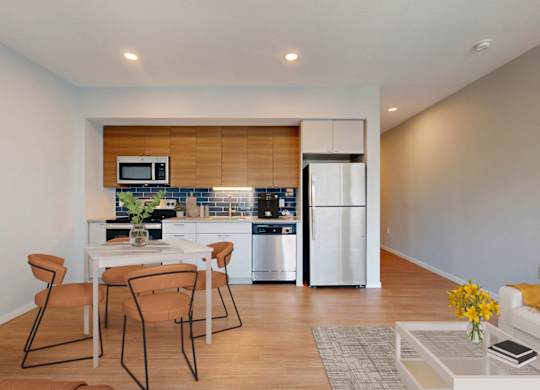 A modern kitchen with a dining table and chairs.