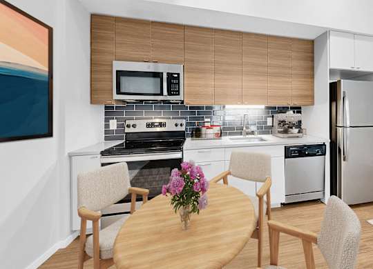 A modern kitchen with a wooden table and chairs.