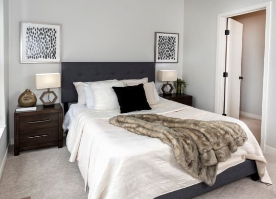 Bedroom with cozy bed and lamps at Volo at Texa Tonka Apartments , St Louis Park, Minnesota