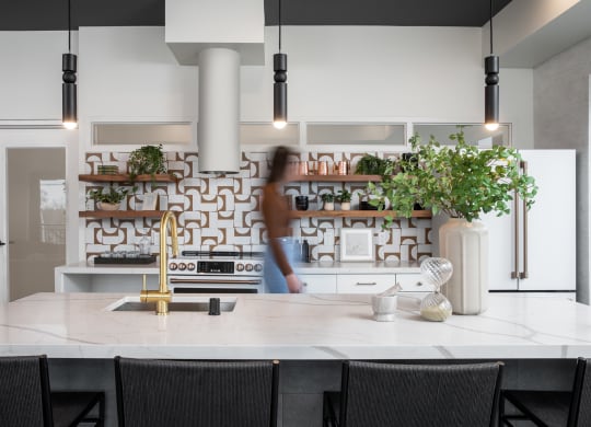 a kitchen with a white counter top and black chairs