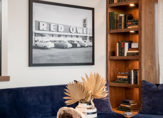 a living room with a blue couch and a coffee table with books and a vase with