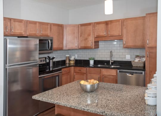 Upgraded kitchen with granite countertops, tile backsplash and stainless steel appliances