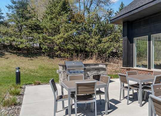 A patio with a table and chairs is set up outside a house.